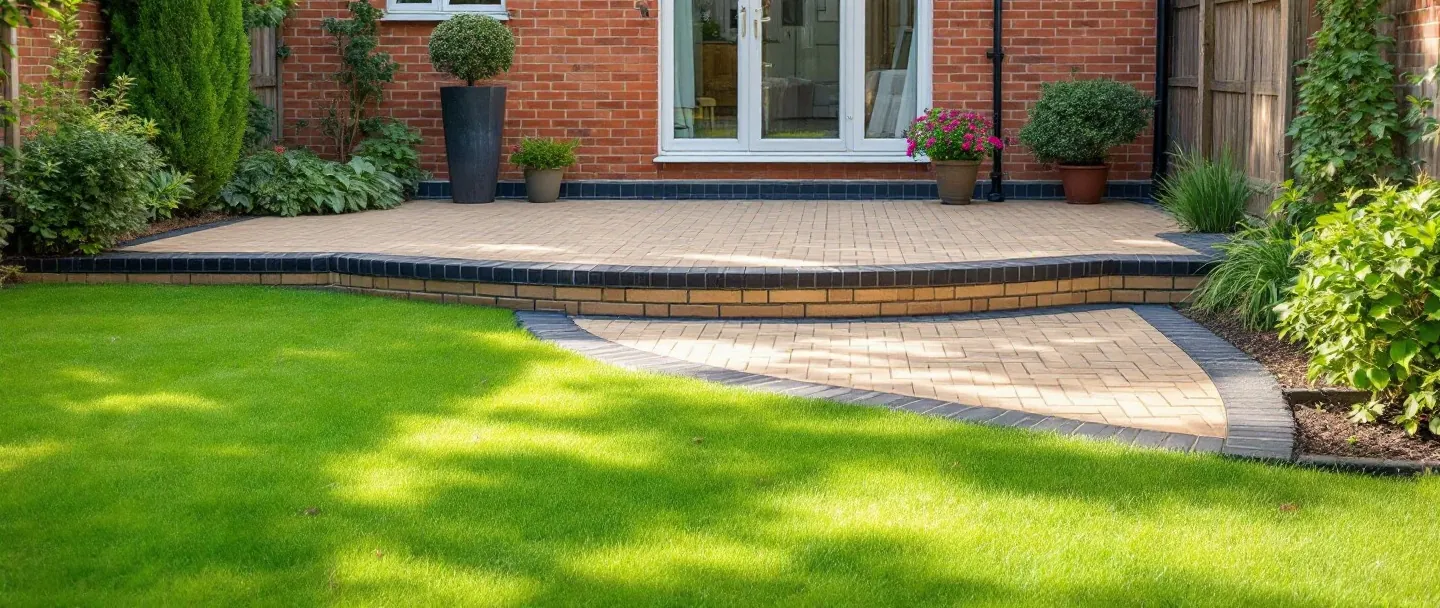 Block paving patio with a low step down to the lawn